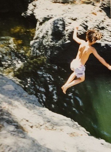 Kelton at about ten, jumping from a rock