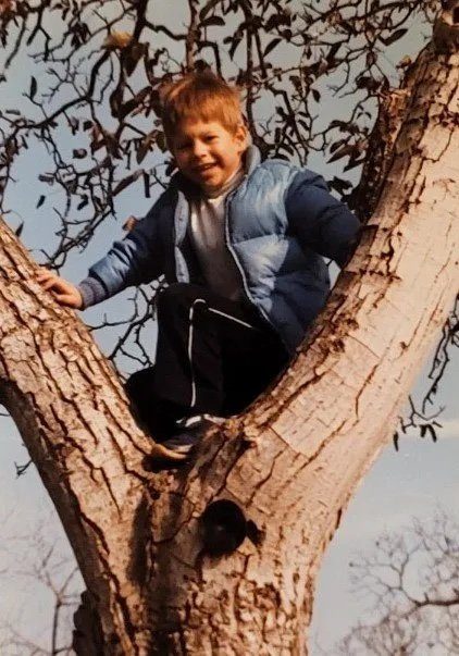 Kelton at about four years old, climbing a tree
